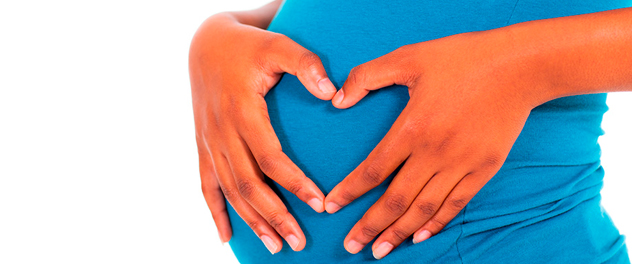 Pregnant mother, heart shaped hands on her belly.