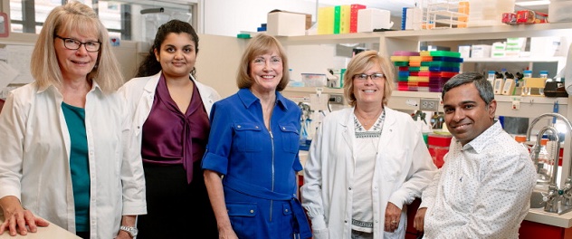 Photograph of Dr. Conover and four colleagues standing in a laboratory setting