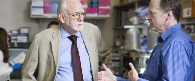 Larry R. Pease, Ph.D., discussing a research project with a colleague