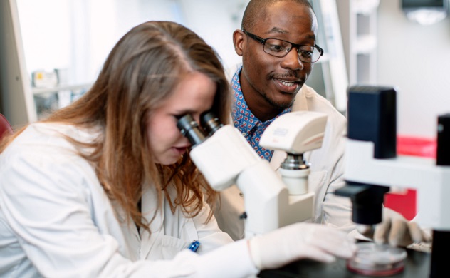 Research trainees using microscope