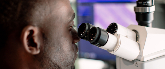 Research fellow using a microscope.