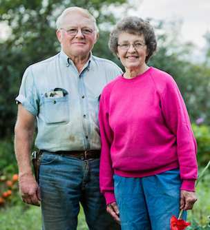 Retired couple posing in their garden.