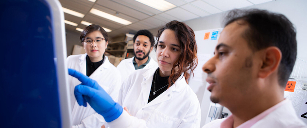 Lab team members interacting with lab equipment