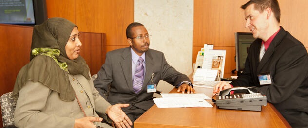 Three people sitting around a desk, one an interpreter for a Somali patient.