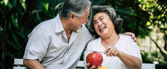 Older couple on bench with fruit