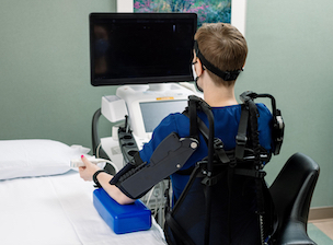 Cardiac sonographer simulates left-handed exoskeleton testing on repetitive tasks.