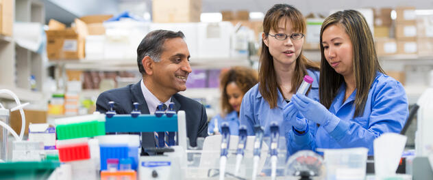 A photograph of Tushar C. Patel, M.B., Ch.B., in the lab with two colleagues working with test tubes