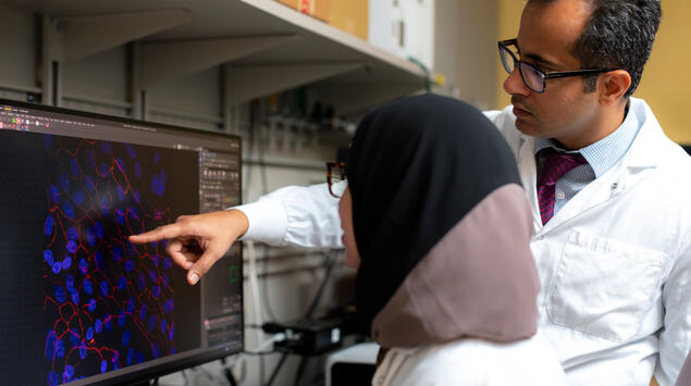 Dr. Grover discussing tissue sample with lab member