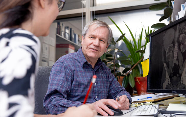 Dr. Harris and a staff member analyze research images on a computer screen.